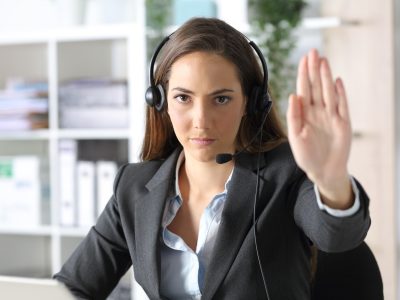Front,View,Of,A,Serious,Telemarketer,Woman,With,Headset,Gesturing