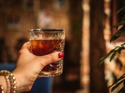 Woman’s hand holding glass of iced coffee