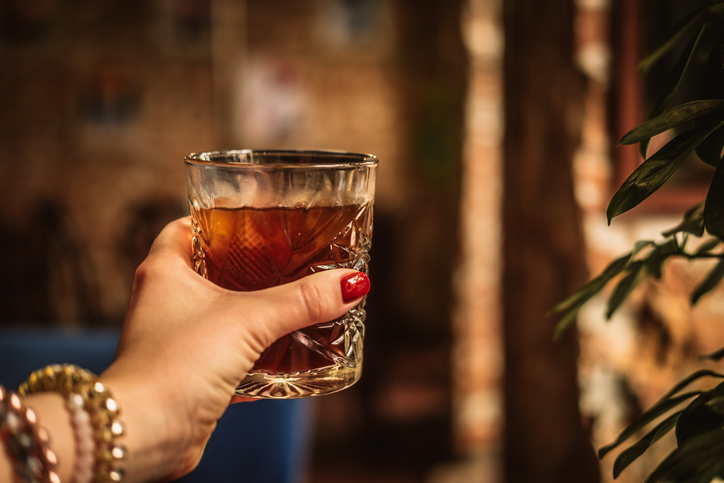 Woman’s hand holding glass of iced coffee